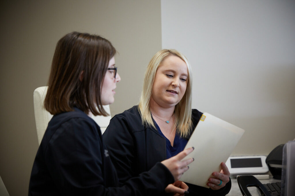 Desert Valley Oral Surgery employees looking over insurance information