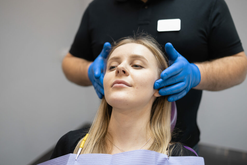 surgeon palpitating a woman's jaw