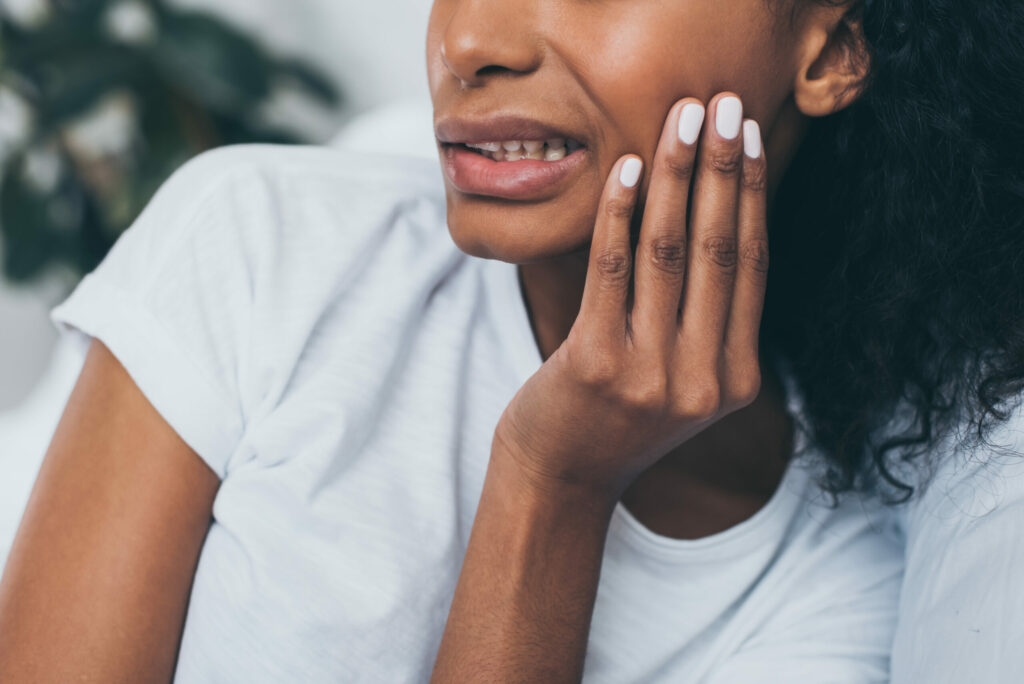 young woman holding her jaw in pain